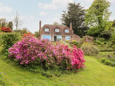 a house with pink flowers in front of it at Flushing Meadow in Helston