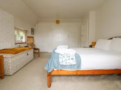 a bedroom with a large bed and a couch at Flushing Meadow in Helston