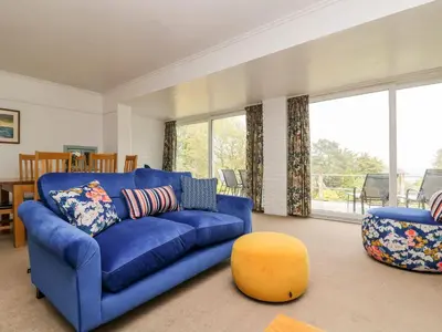 a living room with a blue couch and a chair at Flushing Meadow in Helston