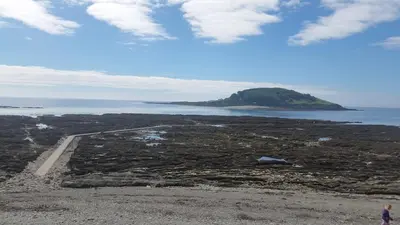 an island in the ocean with a dirt road at Looe Holiday Home Cornwall Sleeps 2 Self Catering No Pets in Looe