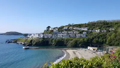 a view of a beach with houses on a hill at Looe Holiday Home Cornwall Sleeps 2 Self Catering No Pets in Looe
