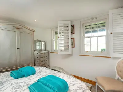 a bedroom with a bed with blue towels on it at Wheal Trenwith Cottage in St Ives