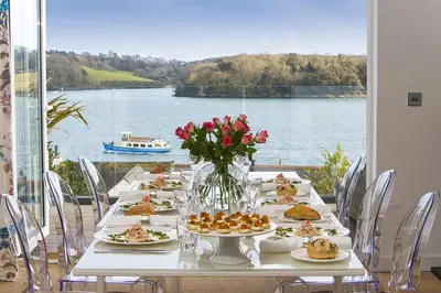 a table with plates of food and a view of the water at Dreamcatchers in Truro