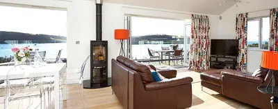 a living room with couches and a table and a television at Dreamcatchers in Truro