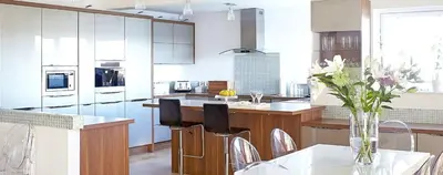 a kitchen with white cabinets and a table with chairs at Dreamcatchers in Truro