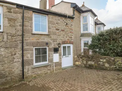 an old stone house with a white door at Blue Skies in Hayle