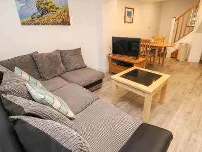 a living room with a couch and a tv at Blue Skies in Hayle