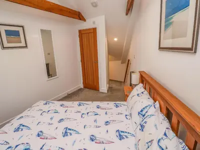a bedroom with a bed and a wooden railing at Blue Skies in Hayle