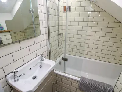 a white bathroom with a sink and a shower at Blue Skies in Hayle