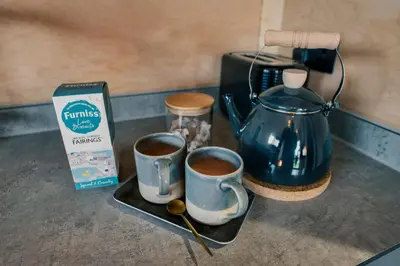 two cups of coffee on a tray next to a coffee maker at Luxury Glamping Cabin with Outdoor Bath on Cornish Meadow in Truro