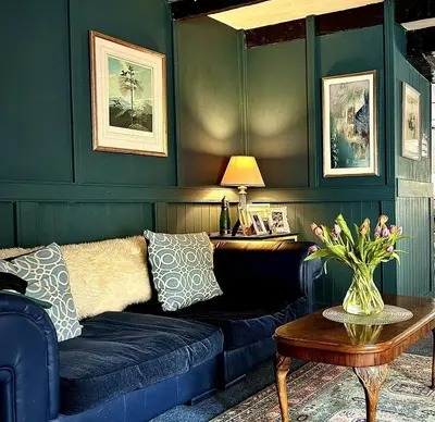 a living room with a blue couch and a table at Britannia House Vintage B&B Cornwall in Helston