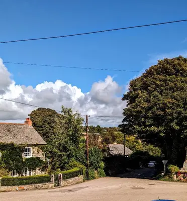 a house with a tree in the middle of a street at Britannia House Vintage B&B Cornwall in Helston