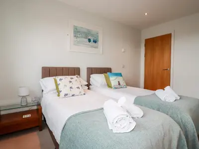 a bedroom with two beds with towels on them at Fistral Pearl in Newquay