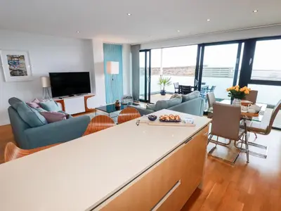 a living room with a kitchen and a living room at Fistral Pearl in Newquay