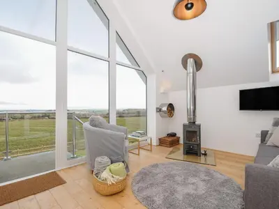 a living room with a fireplace and a tv at Spires in Truro