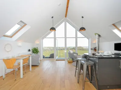 a kitchen and living room with a large window at Spires in Truro