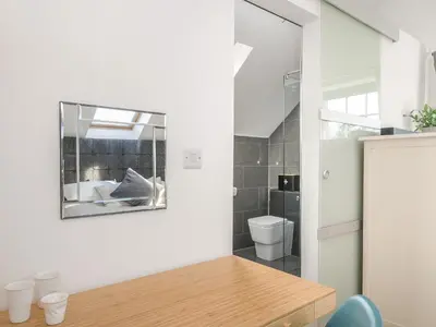 a bathroom with a mirror and a toilet at Spires in Truro
