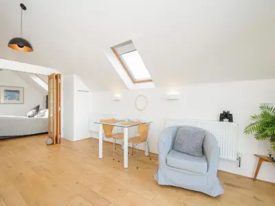 a living room with a table and chairs and a bed at Spires in Truro