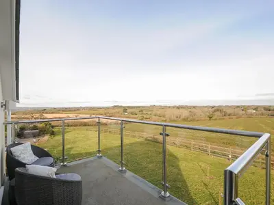 a balcony with chairs and a view of a field at Spires in Truro