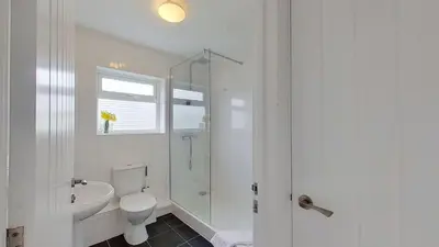 a white bathroom with a toilet and a shower at F13 Trefusis, Riviere Towans in Hayle