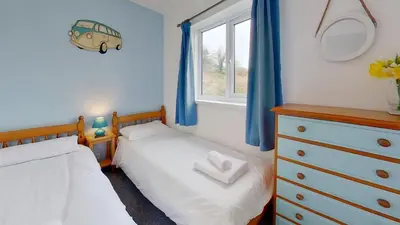 two twin beds in a bedroom with a window at F13 Trefusis, Riviere Towans in Hayle
