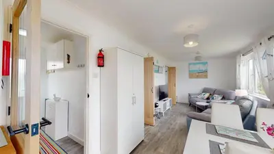 a living room with a couch and a table at F24 Glenara, Riviere Towans in Hayle