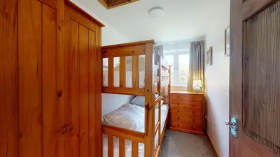a bedroom with two bunk beds and a dresser at F26 Porthia, Riviere Towans in Hayle