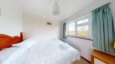 a bedroom with a bed and a window at F30 Fernside, Riviere Towans in Hayle