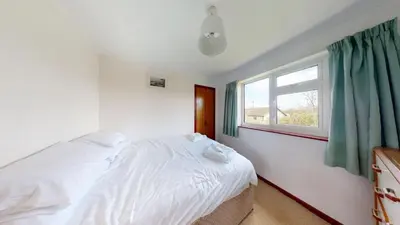 a bedroom with a white bed and a window at F30 Fernside, Riviere Towans in Hayle