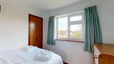 a bedroom with a bed and a window at F30 Fernside, Riviere Towans in Hayle