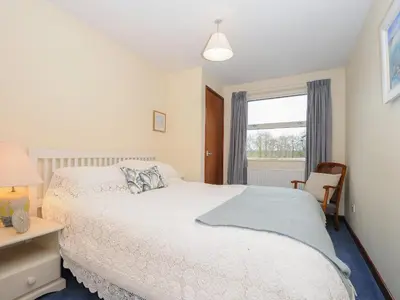 a bedroom with a white bed and a window at Kirland in Wadebridge