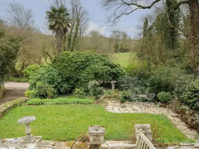 a garden with a table and chairs in it at Kirland in Wadebridge