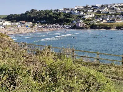 a beach with a bunch of people in the water at Kirland in Wadebridge