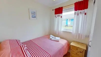 a small bedroom with a bed and a window at F40 Bayford, Riviere Towans in Hayle