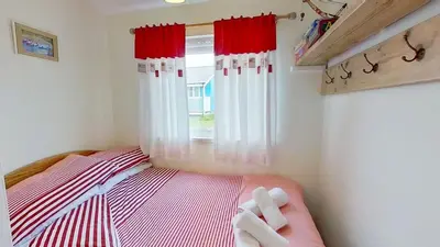 a small bedroom with a bed and a window at F40 Bayford, Riviere Towans in Hayle