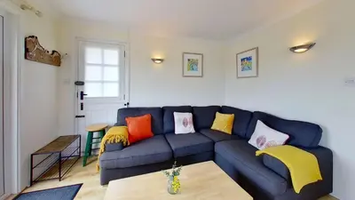 a living room with a blue couch with colorful pillows at F40 Bayford, Riviere Towans in Hayle
