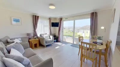 a living room with a couch and a table at F49 Junesta, Riviere Towans in Hayle