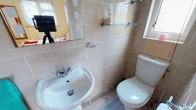 a bathroom with a toilet and a sink and a mirror at F43 Hazebrook, Riviere Towans in Hayle