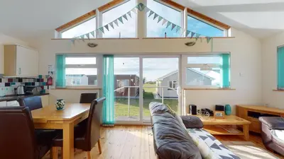 a living room with a couch and a table at F43 Hazebrook, Riviere Towans in Hayle