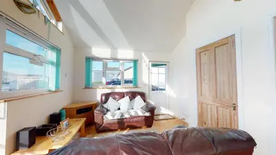 a living room with a couch and a chair at F43 Hazebrook, Riviere Towans in Hayle