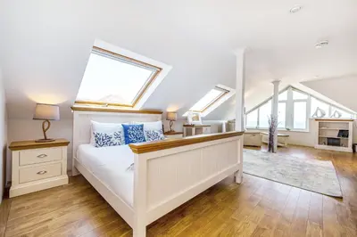 a bedroom with a white bed with skylights at Carbis Bay - Luxury 3 Bed Penthouse Apartment with Sea Views Parking Sauna Balcony in Carbis Bay