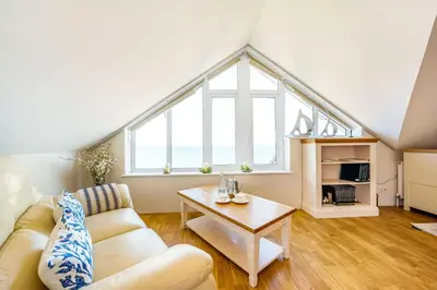 a living room with a couch and a table at Carbis Bay - Luxury 3 Bed Penthouse Apartment with Sea Views Parking Sauna Balcony in Carbis Bay
