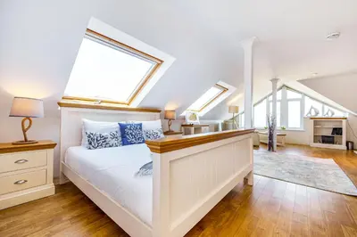 a bedroom with a white bed and skylights at Carbis Bay - Luxury 3 Bed Penthouse Apartment with Sea Views Parking Sauna Balcony in Carbis Bay