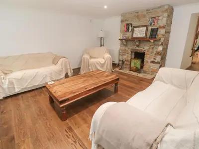 a living room with a table and a fireplace at Sunnyvale Cottage in Penzance