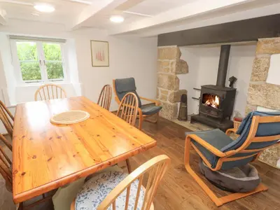 a dining room with a table and a fireplace at Sunnyvale Cottage in Penzance
