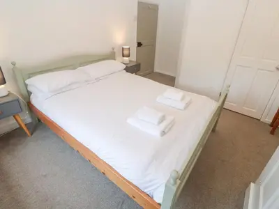 a bedroom with a bed with two towels on it at Sunnyvale Cottage in Penzance