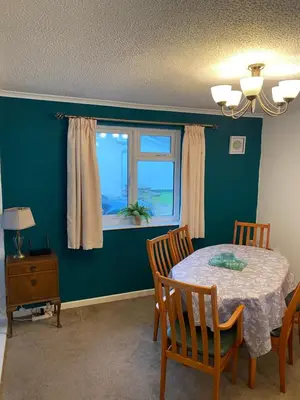a dining room with a table and chairs and a window at Light and bright 3 bedroom bungalow in Cornwall in Liskeard