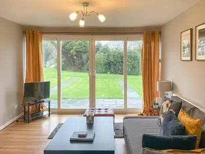 a living room with a couch and a large window at Atlantic Lodge in Saint Columb Major
