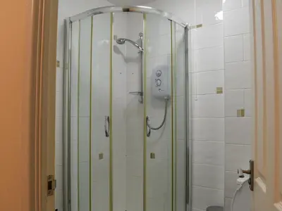a shower with a glass door in a bathroom at Atlantic Lodge in Saint Columb Major