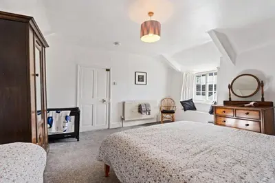 a bedroom with a bed and a dresser and a mirror at Myrtle Cottage Boscastle in Boscastle
